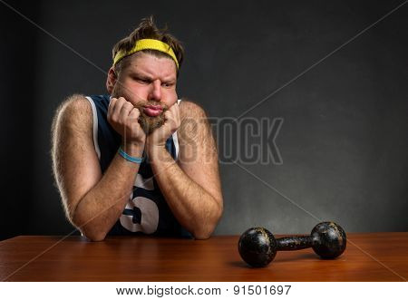 Sad man with a dumbbell