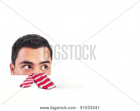 Shocked man peeking behind a blank white desk