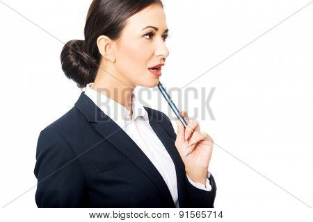 Portrait of businesswoman holding pen under chin.
