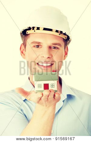 A forewoman holding a model house in hand