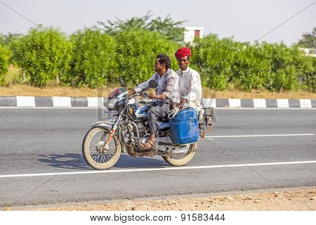 Men Riding On Scooter Through Busy Highway