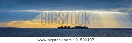Panorama of lake sunset with sunrays coming through clouds. Lake Narach, Belarus