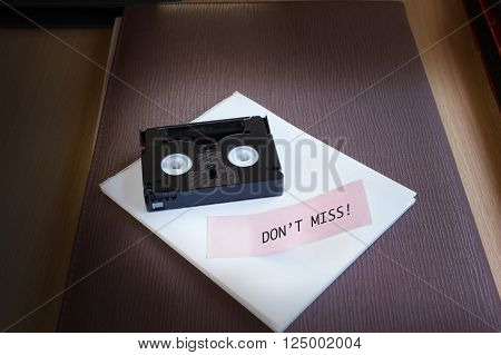 Mini Dv Cassette Tape On Note Text Word  Do Not Miss In Dim Light Room Nackground With Copy Space