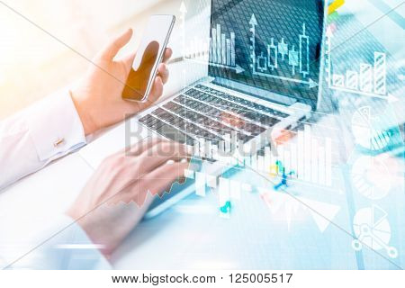 Businessman typing on laptop smartphone in hand. Only hands seen. Double exposure. Concept of work.