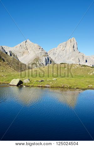 Peaks reflected in Ansabere Lake. Lescun Cirque. Aspe Valley, Pyrenees, France.