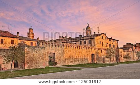 landscape  at dawn of the village Buonconvento, with the medieval city walls and towers, in province of Siena, Tuscany, Italy