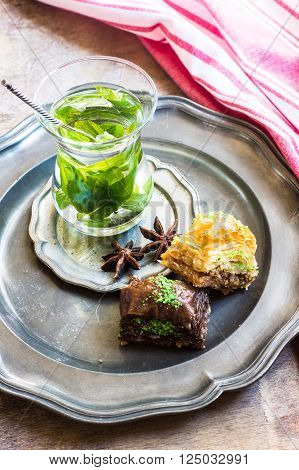 Traditional turkish dessert - mint tea and bakhlava on rustic background