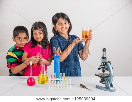 3 indian kids doing science experiment, science Education. asian kids and science experiments, chemistry experiment, indian kids and science experiments, indian kids and science lab