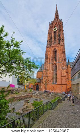 FRANKFURT GERMANY - APRIL 29 2012: Frankfurt Cathedral and Roman ruins in Frankfurt in Germany. It is also called Frankfurter Dom or Cathedral of Saint Bartholomew. Tourists nearby