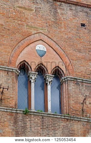 The typical three-part Sienese gothic windows of San Giovanni Square