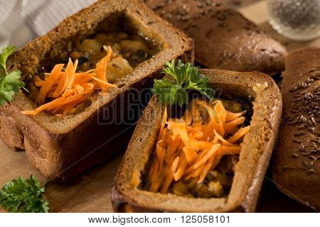 Fresh pea soup in a Bread Bowl, on a wooden board with salt and papper
** Note: Shallow depth of field