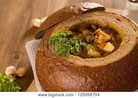 Fresh pea soup in a Bread Bowl, on a wooden board with salt and papper
** Note: Shallow depth of field
