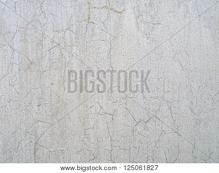 Close-up of cracked paint on the wall. Old weathered painted wall surface. Grunge background with peeling paint