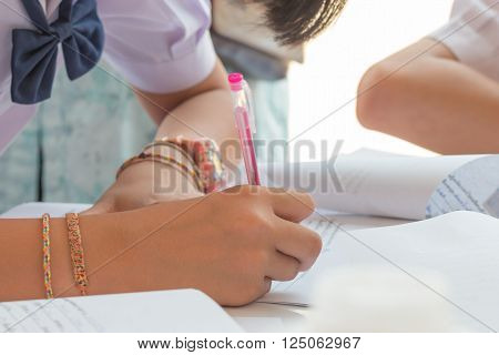 Thai students writing on a paper for Admissions in high school Thailand
