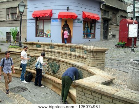 BELGRADE-MAY 13: Unidentified people fill water bottles from historic, artistic water fountains in historic district Skadarlija in capital Belgrade, Serbia on May 13, 2015.