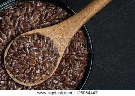 Brown Flax Seed In Bowl With Wooden Spoon And Small Copy Space