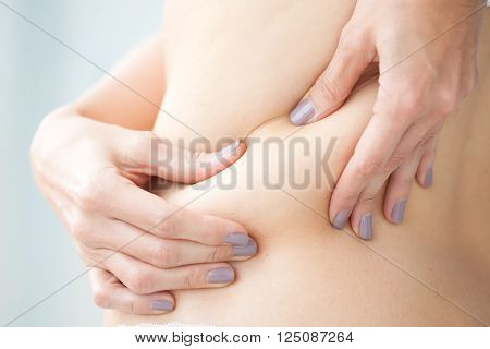 Woman dressed in white showing her back localized fat