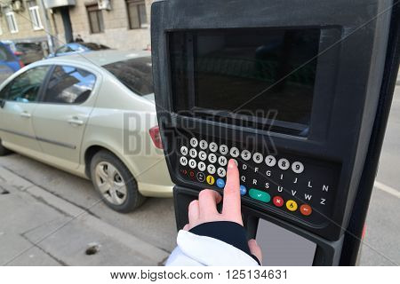 Moscow, Russia - March 14, 2016. Woman's hand enters the data in the parking payment machine