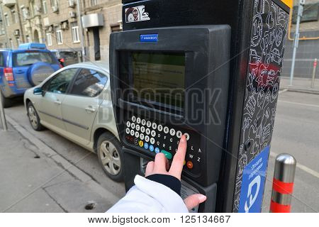 Moscow, Russia - March 14, 2016. Woman's hand enters the data in the parking payment machine