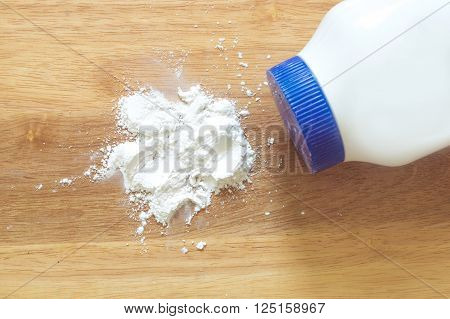 The Talcum white powder on wooden background