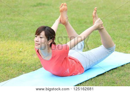 Japanese woman outside doing yoga frog pose