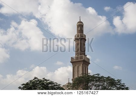 An old mosque minaret against cloud background.
