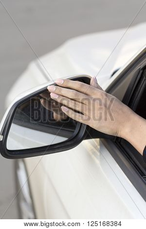 girl on a white machine adjusts the rearview mirror