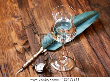 Grappa in a small glas on old wooden table, selective focus