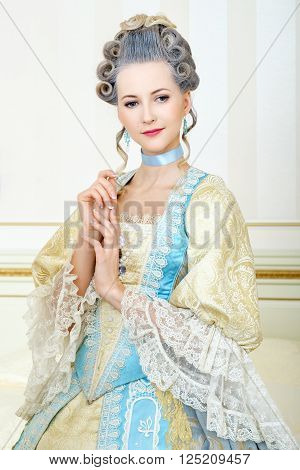 Beautiful woman in historical dress in Baroque style in the interior