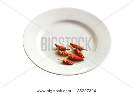 Six small hot red chilli peppers on a white plate.