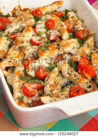 Italian chicken bake casserole with mozzarella cherry tomatoes and oregano close up