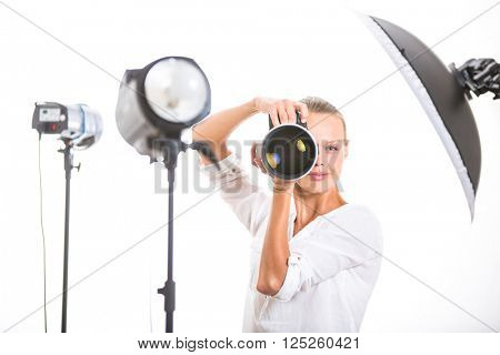 Pretty, female photographer with digital camera - DSLR and a huge telephoto lens (color toned image; shallow DOF)
