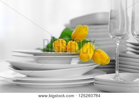 Set of dishes with yellow tulips for dinner party