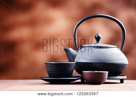 Black pialats and teapot on blurred background