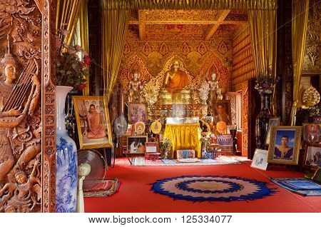 CHIANG MAI, THAILAND - FEB 21, 2016: Many royal portraits and golden sculptures inside ancient Buddhist temple Wat Buppharam on February 21, 2016. The temple was established in 1497 by King Muang Kaew