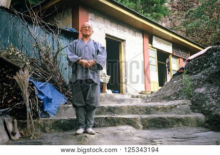 SONGNISAN NATIONAL PARK / KOREA - CIRCA 1987: A Buddhist monk poses for a photograph outside of his hermitage on a mountain in Songnisan National Park.