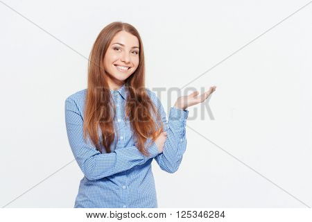 Happy casual woman holding copyspace on the palm isolated on a white background