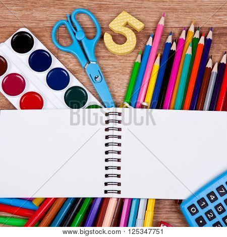 Paints, brushes, colored pencils and album - drawing tools on a desk