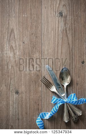 Bavarian cutlery on wooden table with copy space. Oktoberfest beer festival background. Menu for Bavarian specialties