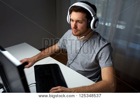 technology, gaming, entertainment, let's play and people concept - young man in headset with pc computer playing game at home and streaming playthrough or walkthrough video