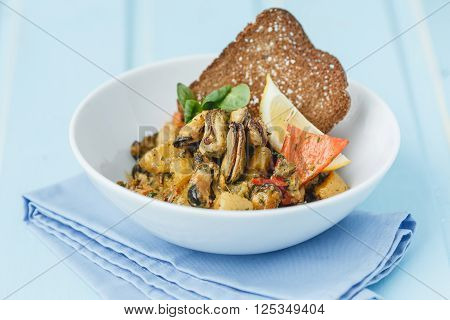 Mussels salad with toast on blue wood backgraund