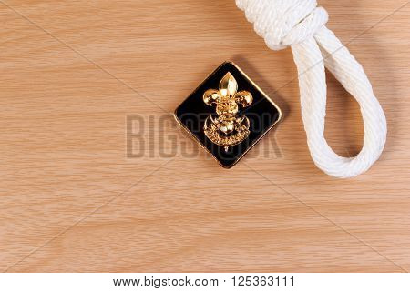 Orderliness White Scout Rope With Vintage Boy Scouts Badge On Wooden Table.
