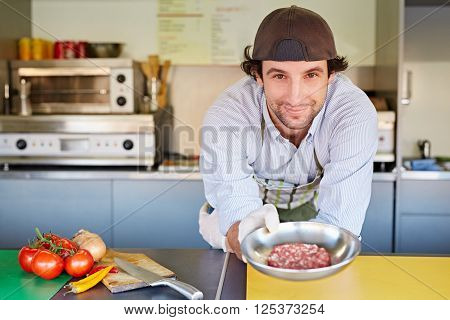 Food entrepeneur holding a bowl of good quality red meat, minced for making hamburger patties