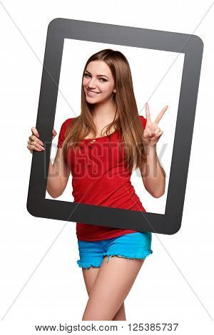 Beautiful bright girl standing looking through the frame and gesturing V sign, over white background