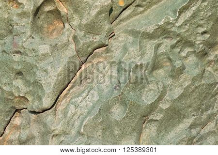 Abstract stone background texture photo of rock in green shade with fracture