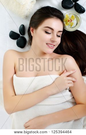 Young spa woman touching her face after beauty treatment