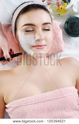 Young spa woman touching her face after beauty treatment