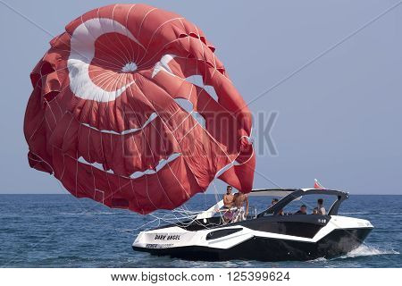CAMYUVA KEMER TURKEY - JULY 11 2015: The team prepares a parachute for parasailing. Parasailing is very popular in the Turkish resorts