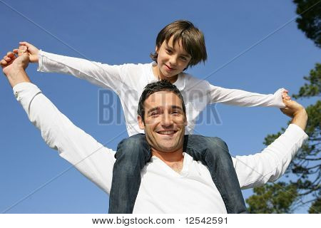 Retrato de um menino sentado sobre os ombros de um homem