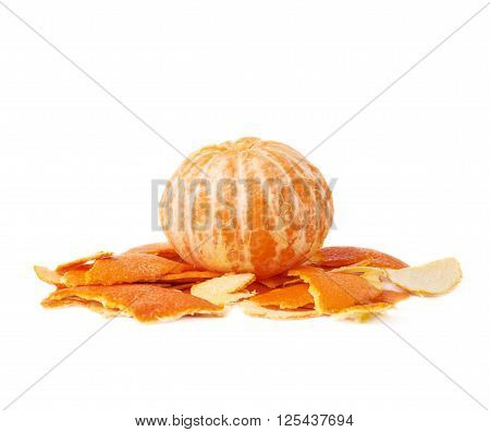 Unpealed cleaned fresh tangerine on a pile of it's peel isolated on white background